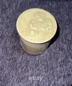 An antique carved celluloid powder box