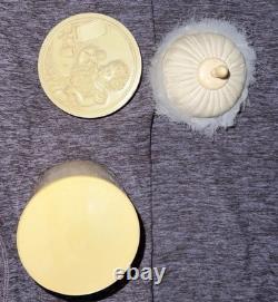 An antique carved celluloid powder box