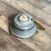 Vintage metal musical powder box with butterscotch bakelite handle and porcelain medallion lid