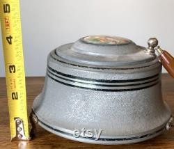 Vintage metal musical powder box with butterscotch bakelite handle and porcelain medallion lid
