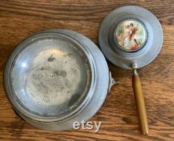 Vintage metal musical powder box with butterscotch bakelite handle and porcelain medallion lid