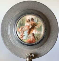 Vintage metal musical powder box with butterscotch bakelite handle and porcelain medallion lid
