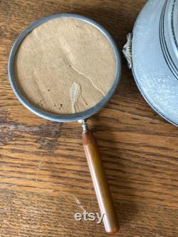 Vintage metal musical powder box with butterscotch bakelite handle and porcelain medallion lid