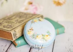 Vintage porcelain powder trinket box, lovely, soft painted yellow roses on a light blue background