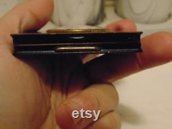 Vintage pre owned small metal powder compact with enameled flowers made by Marathon